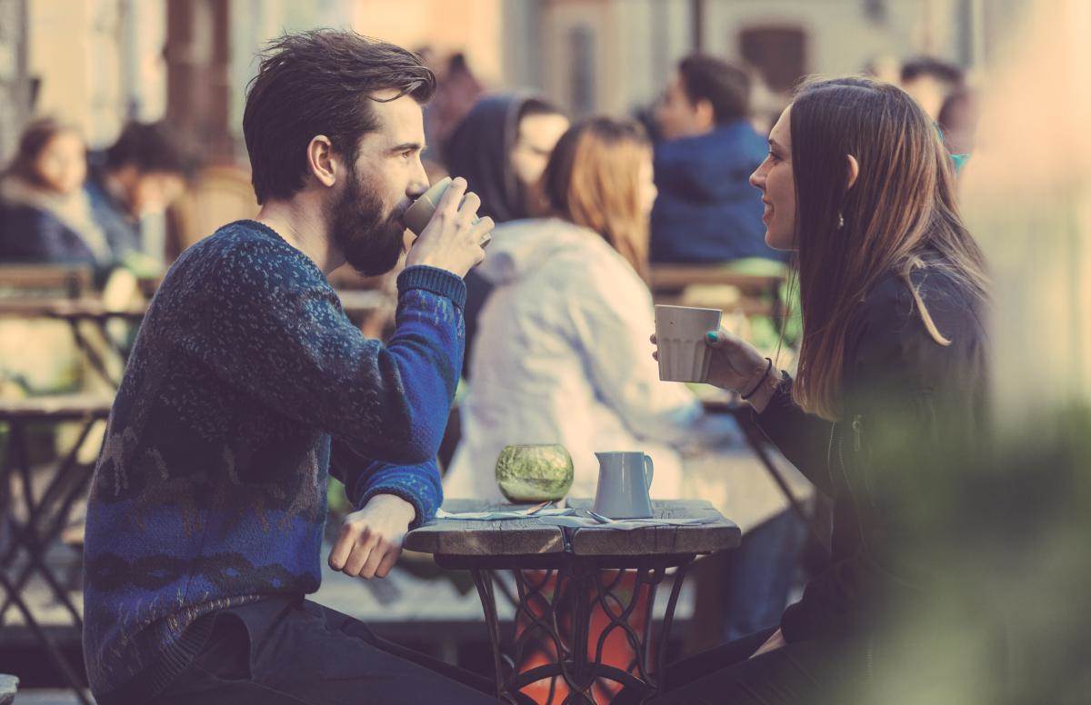  Muškarac i žena sede u kafiću i piju kafu 