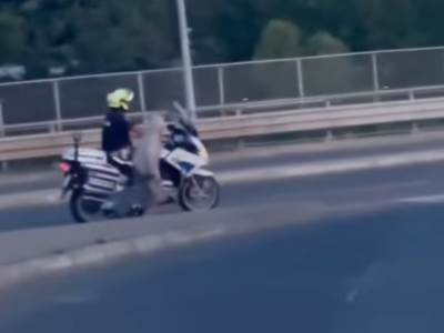  policajac na motoru prevodi staricu preko mosta na Adi 